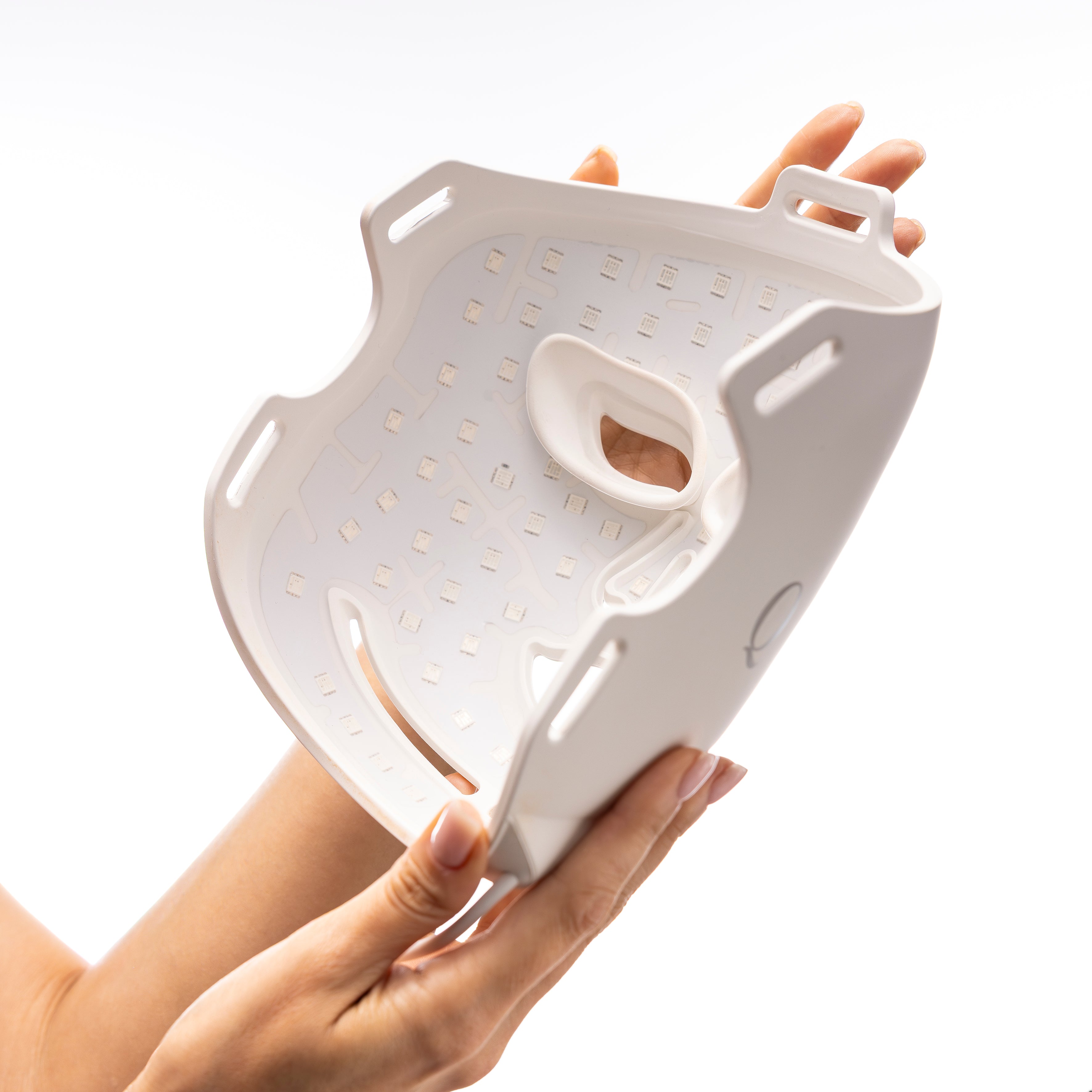 Woman wearing the Quellor LED mask, showing its flexible silicone fit against the face.